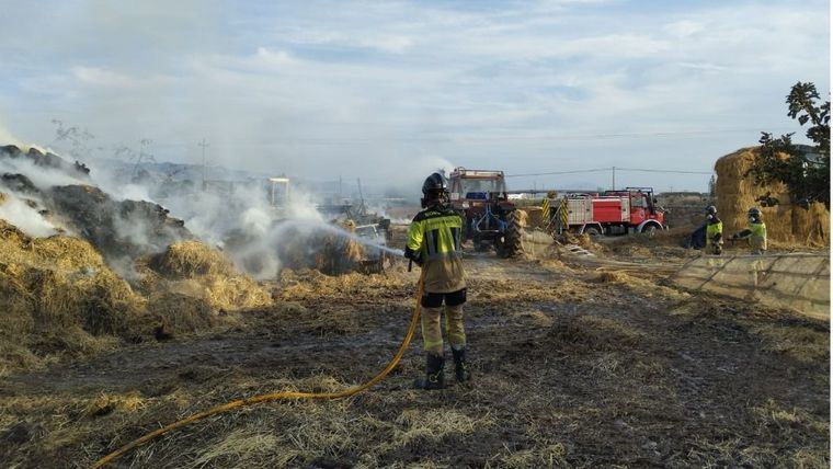 Incendio en un terreno agrícola con restos de poda y balas de paja